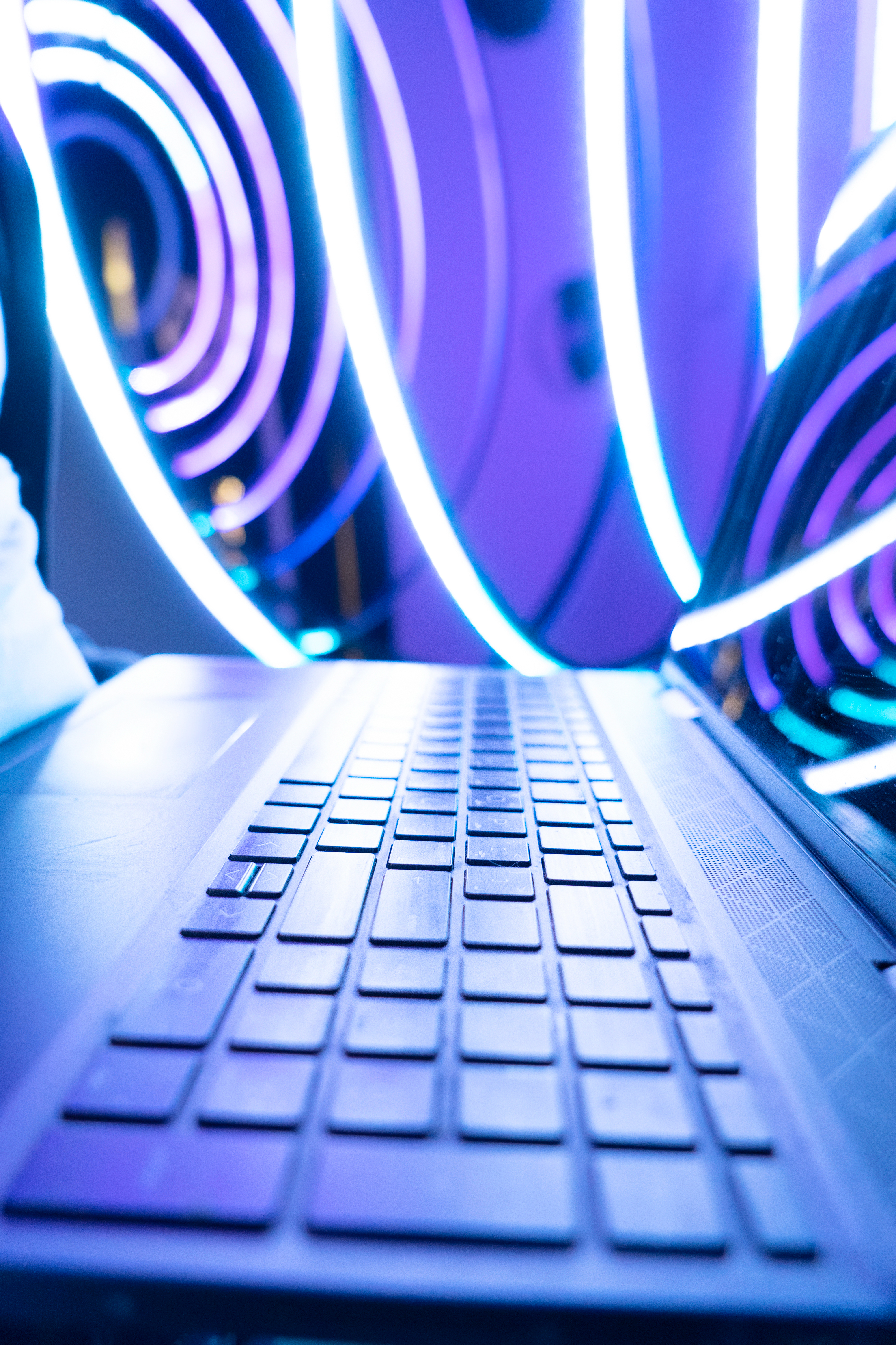 Laptop keyboard with neon lights in the background