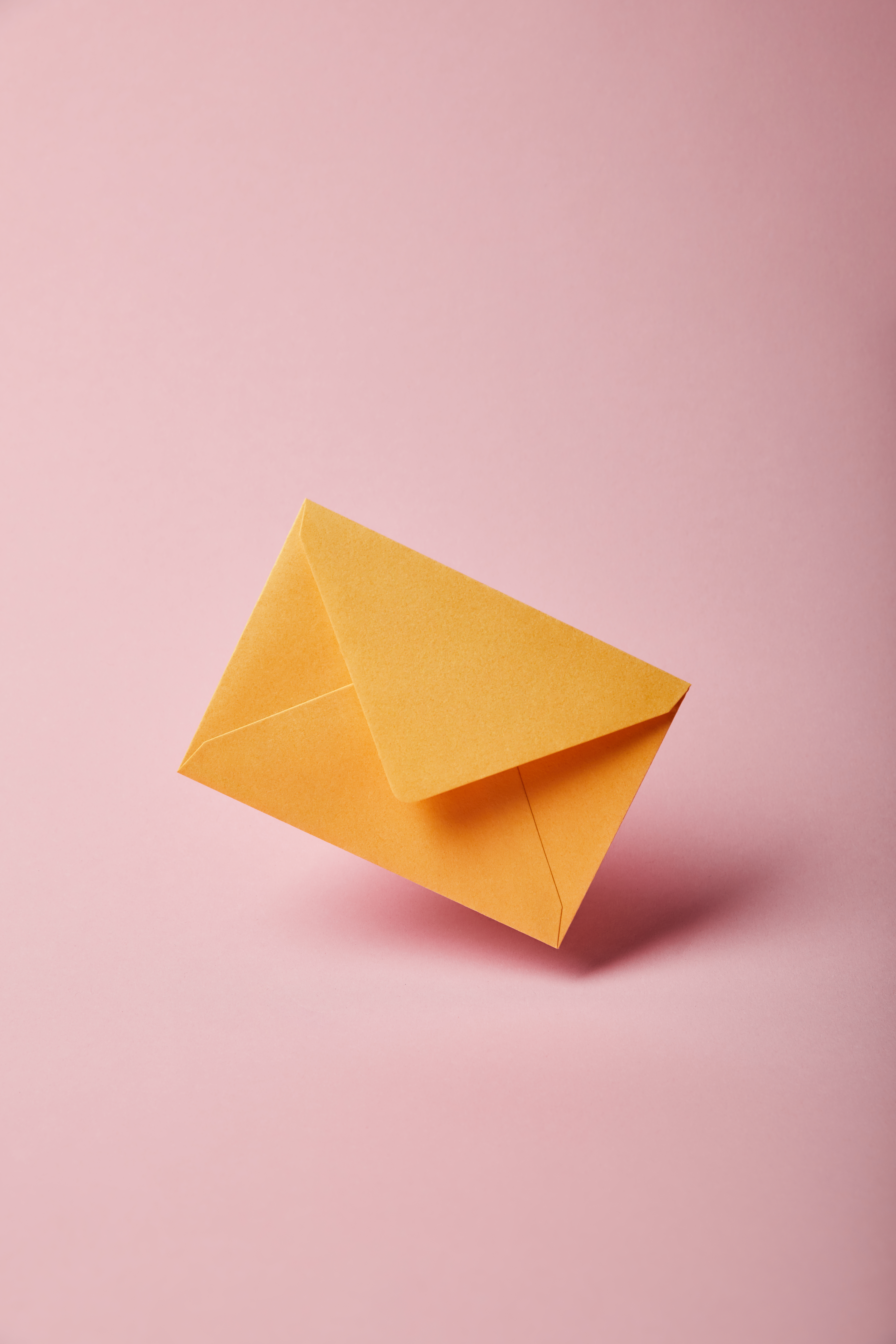 Photo of an orange envelope on a pink background