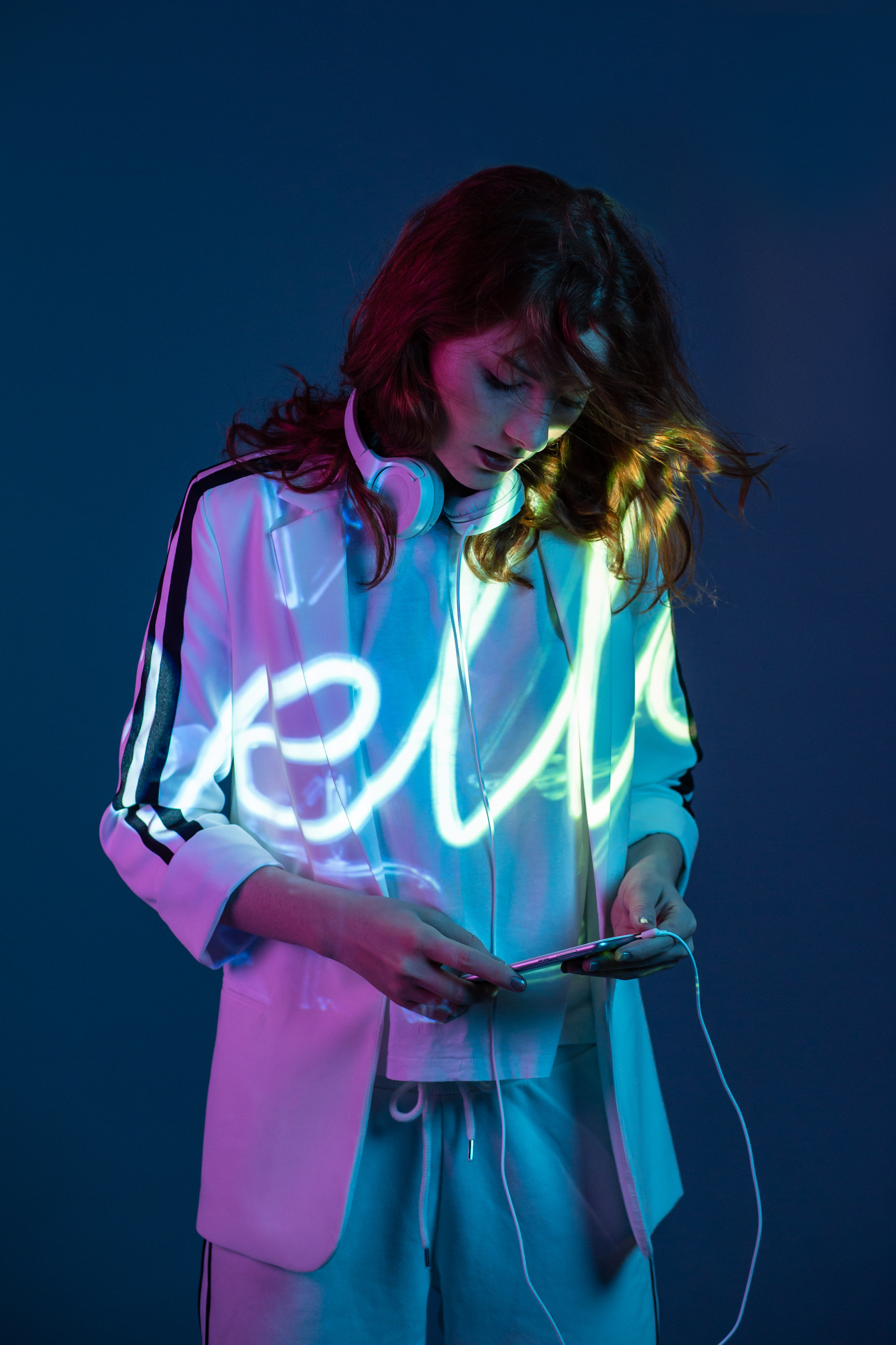 Woman with hello projected on to her, looking at her phone engaging with it